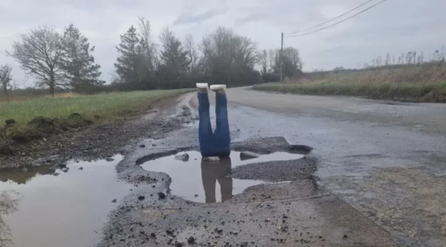 Fake Legs Erected In Large Pothole