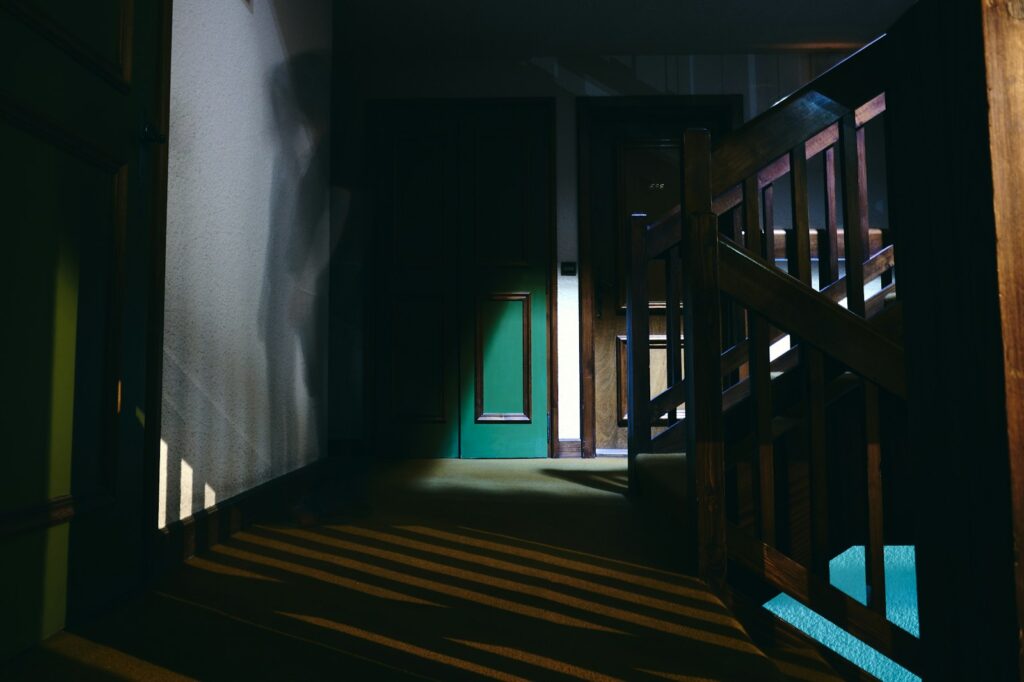A dark hallway with stairs leading to another room