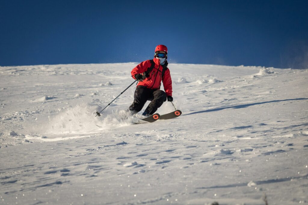 A man riding skis down a snow covered slope