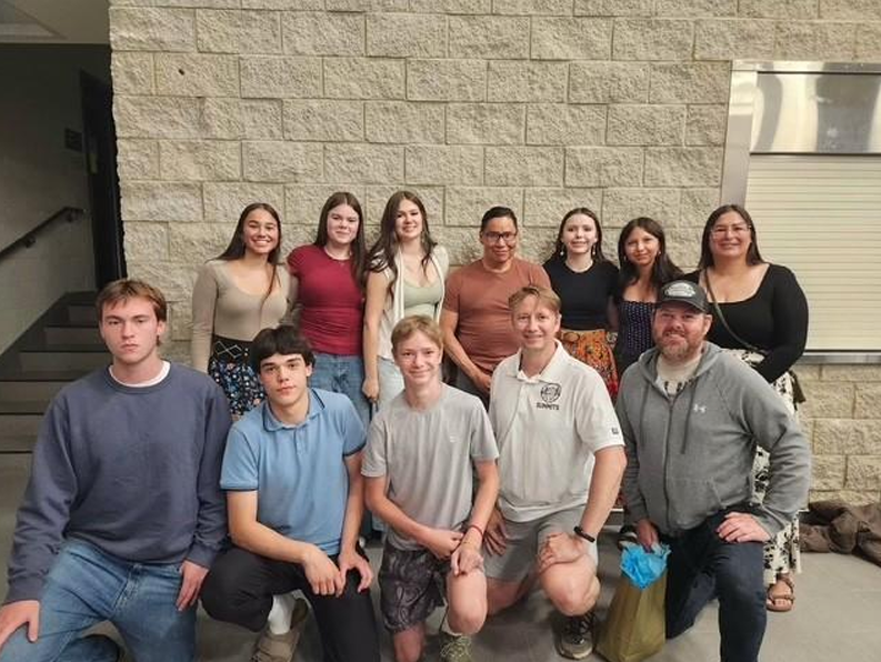 Pictured Community Volleyball Champion (Back Center) alongside current and past players he has coached.